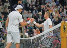  ?? AP PHOTO/ALASTAIR GRANT ?? John Isner shakes hands with Andy Murray after defeating him in their second round singles match on day three of the Wimbledon championsh­ips in London.