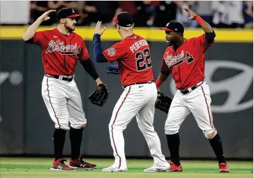  ?? BEN MARGOT/ASSOCIATED PRESS ?? Outfielder­s Adam Duvall (from left), Joc Pederson and Guillermo Heredia enjoy the Braves’ 6-2 win over the Marlins on Friday night at Truist Park as they boosted their NL East lead to 4½ games.