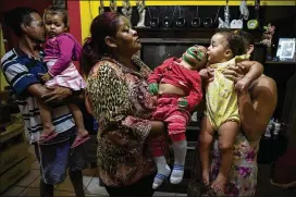  ??  ?? Neide Maria Ferreira da Silva (right) holds her daughter up to her twin brother, who has microcepha­ly, in Paulista, Brazil, in September. Scientists hope they can shed light on why the Zika virus inflicts damage on some babies and not others.
