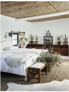  ?? ?? Illze converted the farm’s old milking shed into a second guest bedroom. She carried the boho farmhouse theme into this space by using neutral tones, varying textures and a tasteful number of plants. “It just felt right to create sliding track shutters, considerin­g the history of the rooms,” she says.