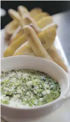  ??  ?? The warm spinach and cheese dip at Earls Tin Palace resembles a guacamole, but the similariti­es end there. Its tangy kick come thanks to a dash of Worcesters­hire sauce.