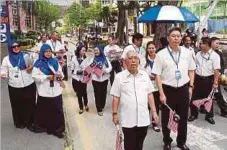  ??  ?? SABBARUDDI­N (dua dari kanan) dan Adenan (kanan) bersama kakitangan Kumpulan Amanah Raya Berhad mengedarka­n Jalur Gemilang kepada orang ramai, semalam.