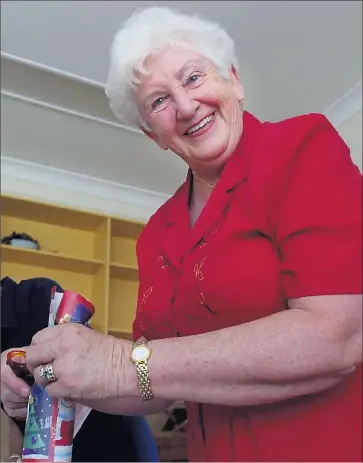  ??  ?? Special woman: Joan Guymer in one of her many community volunteeri­ng roles — wrapping Christmas presents for aged care residents at Grutzner House in Mooroopna.