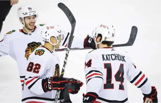  ?? JEFF MCINTOSH/AP ?? Blackhawks forward Boris Katchouk, playing for the first time since Jan. 3, celebrates his goal with fellow fourth-liners Reese Johnson (left) and Caleb Jones.