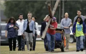  ?? ERIC GAY — THE ASSOCIATED PRESS ?? Stephen Hope carries a cross as he and other leave after a worship service for the victims of the shooting at Sutherland Springs Baptist Church, Sunday in Sutherland Springs, Texas, a week after a man opened fire inside the church. Church members will...