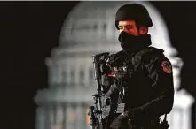  ?? John Minchillo / Associated Press ?? An armed police officer guards a checkpoint as part of the increased security ahead of President Joe Biden’s inaugurati­on.