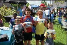  ??  ?? Children show off the school supplies they received Saturday afternoon.