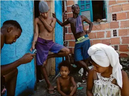  ?? Raphael Muller/Folhapress ?? Moradores do bairro Lobato, em Salvador, que sofrem com falta de renda e o medo do vírus e de deslizamen­tos