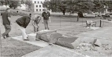  ?? Jill Bleed / Associated Press ?? Personnel from the Secretary of State’s Office inspect the damage to the new Ten Commandmen­ts monument Wednesday outside the state Capitol in Little Rock, Ark., after someone crashed into it with a vehicle.