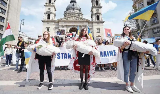  ?? Agence France-presse ?? ↑
Demonstrat­ors, with their action alluding to children killed in Russia’s war in Ukraine, during a protest in Budapest on Saturday.