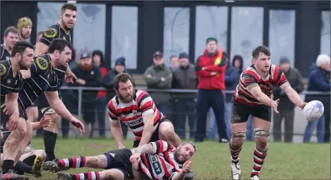  ??  ?? Enniscorth­y’s Alan Jacob gets a pass away with team-mates Paddy Waters and Angelo Todisco grounded.