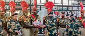  ??  ?? GESTURE: Border Security Force director-general Rakesh Asthana offers sweets to soldiers during the celebratio­ns at the Attari-Wagah border
