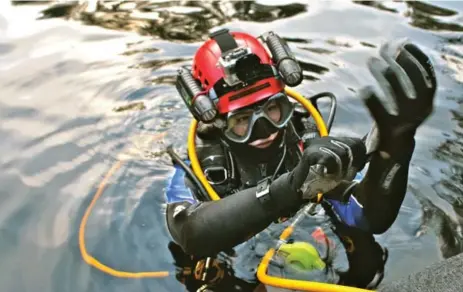  ?? BRENDAN FENERTY ?? Valérie Brosseau, a student at the University of Toronto who is working on unearthing the underwater sinkhole, prepares to dive. “It is essentiall­y a terrestria­l or dry land dig, but underwater . . . excavating an area centimetre by centimetre,” said...