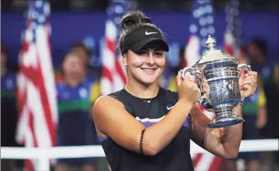  ?? Charles Krupa / Associated Press ?? Bianca Andreescu holds up the championsh­ip trophy after defeating Serena Williams in the women’s singles final of the U.S. Open in 2019.