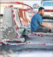  ?? AFP ?? An Iraqi man sits on the tarmac at the site of a car bomb attack, in the southern Iraqi city of Basra on Saturday