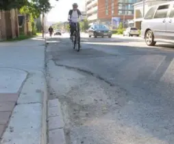  ?? JACK LAKEY/TORONTO STAR ?? A big pothole on the south side of Dundas St., east of Parliament St., forces cyclists to merge with fast-moving traffic to go around it.