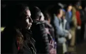  ?? ?? A woman from Cuba waits with other migrants to be processed to seek asylum after crossing the border into the United States near Yuma, Ariz., on Friday.