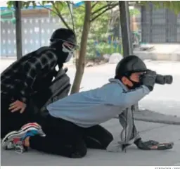  ?? STRINGER / EFE ?? Dos jóvenes disidentes a la junta militar birmana vigilan ayer en Mandalay.