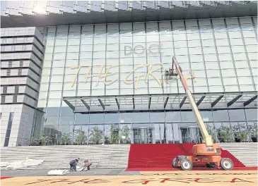  ?? CNS VIA REUTERS ?? Workers remove signs that read ‘Dolce &amp; Gabbana The Great Show’ at the Shanghai Expo Center after the fashion show by the luxury brand was cancelled in Shanghai.