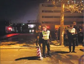  ?? How Hwee Young EPA/Shuttersto­ck ?? POLICE OFFICERS stand at the RYB kindergart­en in Beijing, where some parents have reported that their children were forced to strip naked as punishment and were found with what appeared to be needle marks on their bodies.