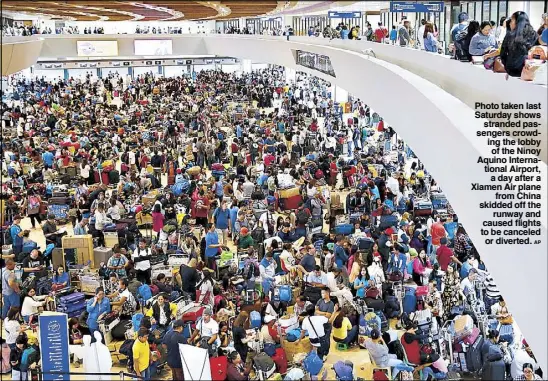  ?? AP ?? Photo taken last Saturday shows stranded passengers crowding the lobby of the Ninoy Aquino Internatio­nal Airport, a day after a Xiamen Air plane from China skidded off the runway and caused flights to be canceled or diverted.