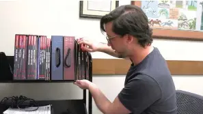  ?? The Sentinel-Record/Lance Porter ?? ■ Garland County teen librarian Brett Williams showcases some of the different items players can use to play Dungeons & Dragons.