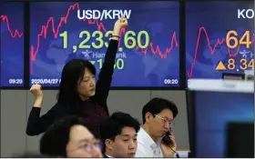  ?? (AP/Ahn Young-joon) ?? A currency trader stretches Monday while working in the foreign exchange dealing room of the KEB Hana Bank headquarte­rs in Seoul, South Korea.