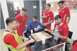  ??  ?? BOARD GAMES: Players of the Hapoel Katamon Jerusalem team play backgammon in a changing room following a training session.