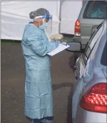  ?? H John Voorhees III / Hearst Connecticu­t Media ?? A medical profession­al registers clients at the Greater Danbury Community Health Center COVID-19 testing site.