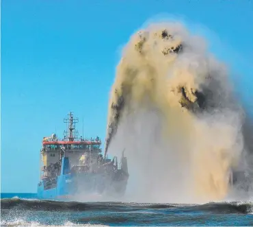  ?? Picture: ED BRANCH ?? The Danish sand dredger Balder R puts on quite a show off Nobbys Beach.