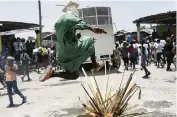  ?? MATIAS DELACROIX AP ?? A person jumps over a fire as gang members demand justice for Jovenel Moïse in Port-au-Prince on Monday.