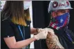  ?? MARY ALTAFFER — THE ASSOCIATED PRESS ?? A nurse inoculates Demetrius Buttelman with the first dose of the Pfizer vaccine at the Belmont Park racetrack in Elmont, N.Y., on Wednesday.