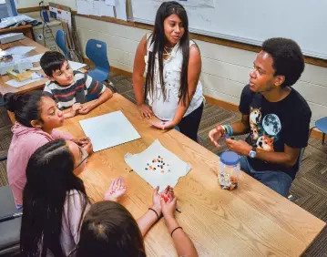  ??  ?? TOP LEFT: Kendall Bell, right, teaches a math class about ratios using jelly beans Tuesday at Santa Fe Preparator­y School. Students in the Breakthrou­gh Santa Fe program take part in lessons that are advanced by at least a year and offer interactiv­e methods.