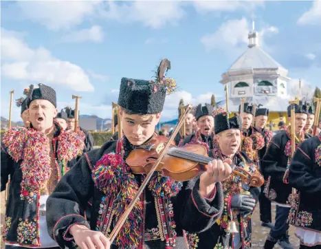  ?? EVGENIYMAL­OLETKA/AP ?? Orthodox Christmas: An ethnic Hutsul man, an ethnic group spanning parts of western Ukraine, plays a violin as others, all wearing traditiona­l clothes, sing a kolyada song Thursday during the Orthodox Christmas celebratio­n in Iltsi village, Ukraine. Orthodox Christians celebrate Christmas on Jan. 7, in accordance with the Julian calendar.