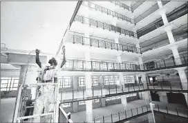  ?? MIKE BROWN/THE COMMERCIAL APPEAL FILES ?? Sam Fallie paints a ceiling in the Crosstown Concourse building. Crosstown High received approval to open in 2017 but officials said in an email Tuesday the school will wait another year.