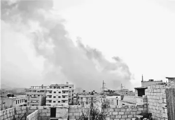  ??  ?? Smoke billows from an explosion in a southern district of the Syrian capital Damascus, during regime strikes targeting the Islamic State group in the Palestinia­n camp of Yarmuk, and neighbouri­ng districts. — AFP photo