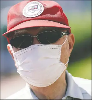  ??  ?? Tamura wears a protective face mask and a sunglass and a cap as he takes a walk as part of his daily routine in Tokyo.