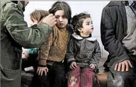  ?? AMMAR SULEIMAN/GETTY-AFP ?? Syrian children wait to be treated at a makeshift hospital in the town of Kafr Batna, where a new wave of strikes killed at least 10 people Wednesday in the suburb east of Damascus.