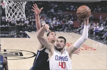  ?? AP PHOTO/MARK J. TERRILL ?? Los Angeles Clippers center Ivica Zubac, right, shoots as Dallas Mavericks center Dwight Powell defends during the first half of an NBA basketball game on Sunday in Los Angeles.