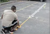  ?? SIBONELO NGCOBO Africa News Agency (ANA) ?? RIGHT: Kishore Hambapersa­d measuring 1.5m markings to ensure social distancing at M Padavatan Primary School. |