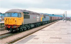  ??  ?? LEFT: Hauling another load of iron ore from Port Talbot to Llanwern, 56040 Oystermout­h leads 56031 Merehead through Cardiff Central on July 16, 1987. At this time, the South Wales PTAs still carried their original grey and orange livery, by now somewhat weatherbea­ten, but repaints into the blue scheme would be underway the following year. (Simon Bendall Collection)