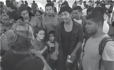  ?? Jerry Lara / Staff photograph­er ?? Volunteer Margarita Croy of Austin talks with Central American migrants at the Mexican immigratio­n offices on Internatio­nal Bridge No. 1 in Nuevo Laredo. Some migrants tell of being kidnapped by gangs.