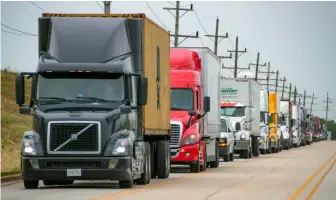  ??  ?? A long line of trucks clogs Centerpoin­t Way adjacent to UP’s Global IV facility on Aug. 11, 2021. Terminal congestion is limiting how many loads draymen can handle in a day, leading some to quit and make a shortage of drivers even worse.