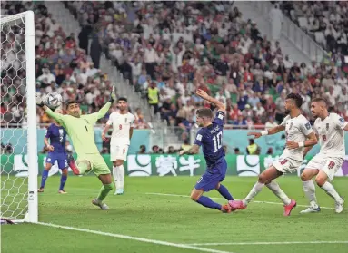  ?? GETTY IMAGES ?? Christian Pulisic scores a goal for the United States past Iran goalkeeper Alireza Beiranvand during a group B match on Tuesday at Al Thumama Stadium in Doha, Qatar.