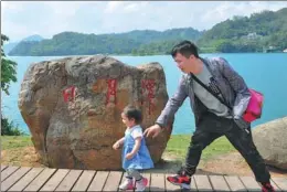  ?? PROVIDED TO CHINA DAILY ?? Sham and his daughter at play during a visit to Sun Moon Lake, Nantou county, Taiwan in April.