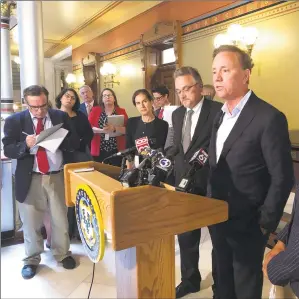  ?? Susan Haigh / Associated Press ?? Gov. Ned Lamont, center, speaks to reporters at the state Capitol following a closeddoor meeting with state lawmakers about electronic tolls on June 19 in Hartford.