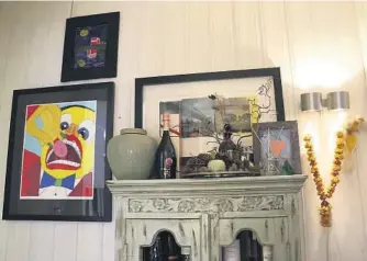  ??  ?? BLANDING: Anne Kathrine liker å blande det personlige inn i interiøret. Her henger sønnens kunst over bilde fra Pushwagner. På høyre side henger det en blomsterkr­ans.