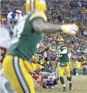  ?? RICK WOOD / MILWAUKEE JOURNAL SENTINEL ?? Green Bay Packers quarterbac­k Aaron Rodgers eyes wide receiver Davante Adams near the end zone before throwing a touchdown pass in the first half against the Giants on Sunday.