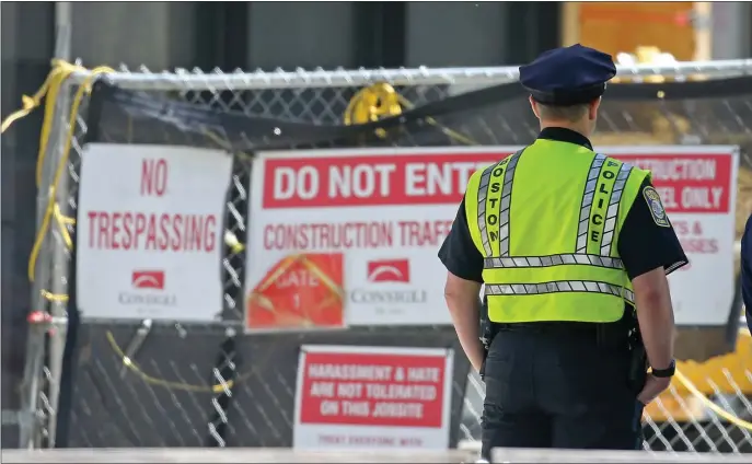  ?? STUART CAHILL / HERALD STAFF ?? ON WATCH: A BPD patrolman guards a crosswalk at a Stuart and Church St. constructi­on zone on Wednesday in Boston.