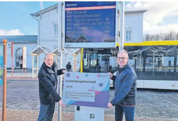  ?? FOTO: CHRISTOS PASVANTIS ?? Udo Winkens (l., Westverkeh­r) und Norbert Reinkober (Go Rheinland) präsentier­en die neue Anzeigetaf­el am Geilenkirc­hener Busbahnhof.